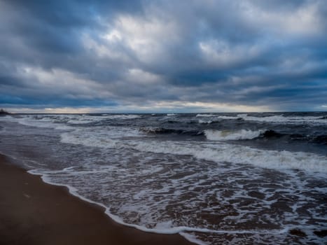 Baltic sea beach with blue cloudy sky and waves