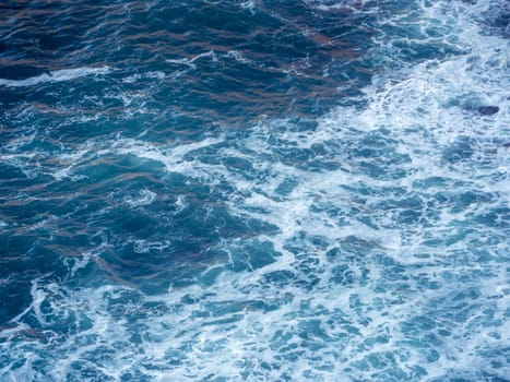 Splashing waves with white foam in ocean
