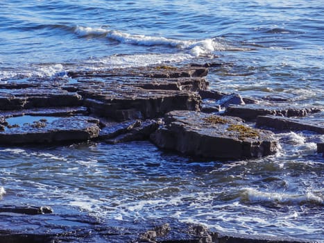 Sea waves lash line impact rock on the ocean beach