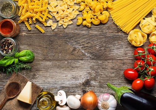 Raw Pasta with ingredients on wooden background