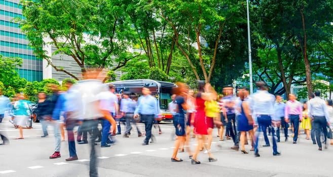 Crowd of business people crossing road in Singapore downtown. motion blur, panorama