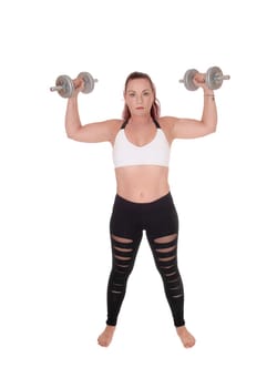 An exercising pretty woman standing in workout outfits and lofting.up the two dumbbells in her hand, isolated for white background.