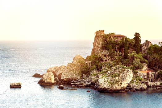 Isola bella islet in the bay of Taormina in Sicily at sunset. Sea and summer season. Tourist destination in Italy