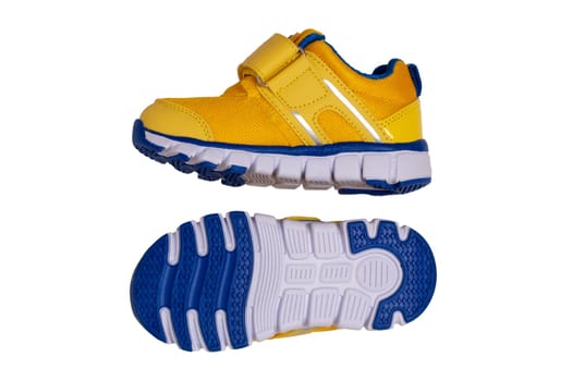 Child shoe fashion. Close-up of a pair of yellow blue child sneaker or sport shoes isolated on a white background. Elegant and trendy shoes for girls. Macro.