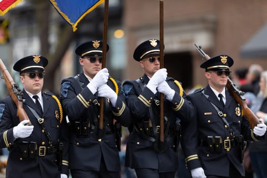 Holland, Michigan, USA - May 11, 2019: Tulip Time Parade, Members of the Holland Police Force, carrying the American flag, marching , during the parade