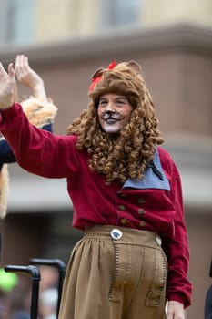 Holland, Michigan, USA - May 11, 2019: Tulip Time Parade, Woman dress up as the lion from the Wizard of Oz, waving at people smiling