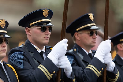 Holland, Michigan, USA - May 11, 2019: Tulip Time Parade, Members of the Holland Police Force, carrying the American flag, marching , during the parade