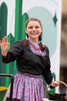Holland, Michigan, USA - May 11, 2019: Tulip Time Parade, Young woman dress up as Dorothy from the Wizard of Oz, Smiling and waving at people during the parade