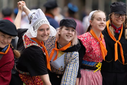 Holland, Michigan, USA - May 11, 2019: Tulip Time Festival, Young women wearing traditional Dutch Clothing dancers in the streets of Holland, Michigan posing for a photo during the Festival
