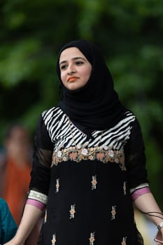 Grand Rapids, Michigan, USA - June 15, 2019: Asian Pacific Festival, Pakistani woman wearing traditional clothing at a fashion display  in the Rosa Parks Circle