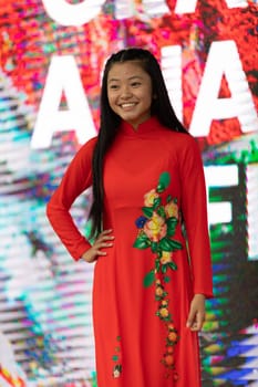 Grand Rapids, Michigan, USA - June 15, 2019: Asian Pacific Festival, Vietnamese woman wearing traditional clothing at a fashion display  in the Rosa Parks Circle