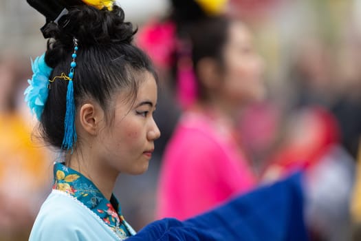Holland, Michigan, USA - May 11, 2019: Tulip Time Parade, Chinese woman wearing traditional clothing, a kimono and flower on her head, at the parade