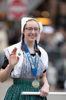 Holland, Michigan, USA - May 11, 2019: Tulip Time Parade, Woman smiles, wearing a traditional dutch outfit during the parade