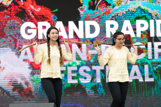 Grand Rapids, Michigan, USA - June 15, 2019: Asian Pacific Festival, Young women, wearing traditional clothing from vietnam, performing traditional dances, at the Rosa Parks Circle