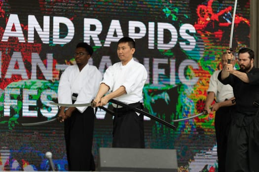 Grand Rapids, Michigan, USA - June 15, 2019: Asian Pacific Festival, Men performing a display of Shindo Munen Ryu swordsmanship at the Rosa Parks Circle