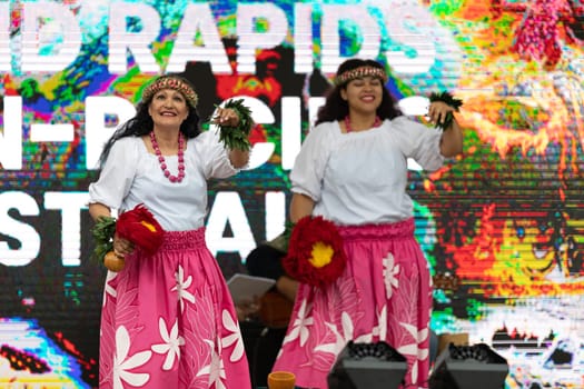 Grand Rapids, Michigan, USA - June 15, 2019: Asian Pacific Festival, Woman wearing traditional clothing performing a hula dance at the Rosa Parks Circle