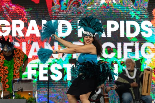 Grand Rapids, Michigan, USA - June 15, 2019: Asian Pacific Festival, Woman wearing traditional clothing performing a hula dance at the Rosa Parks Circle