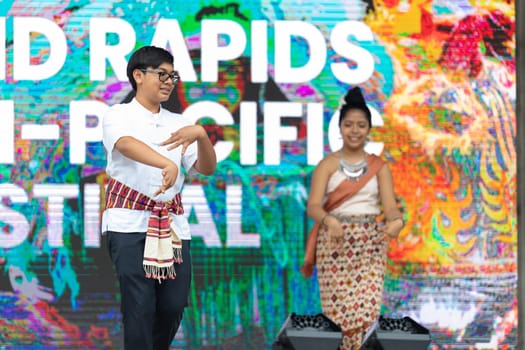 Grand Rapids, Michigan, USA - June 15, 2019: Asian Pacific Festival, thai dancer, wearing traditional clothing, performing a traditional dance at the Rosa Parks Circle