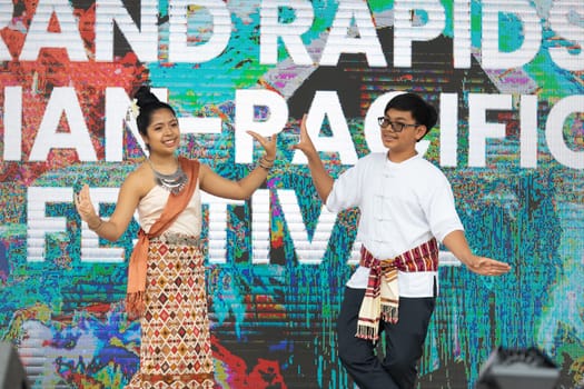 Grand Rapids, Michigan, USA - June 15, 2019: Asian Pacific Festival, thai dancer, wearing traditional clothing, performing a traditional dance at the Rosa Parks Circle