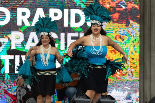 Grand Rapids, Michigan, USA - June 15, 2019: Asian Pacific Festival, Woman wearing traditional clothing performing a hula dance at the Rosa Parks Circle