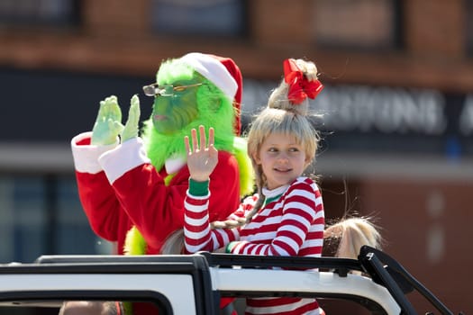 Benton Harbor, Michigan, USA - May 4, 2019: Blossomtime Festival Grand Floral Parade, Car carrying person and girl dress up as the grinch and Cindy Lou Who