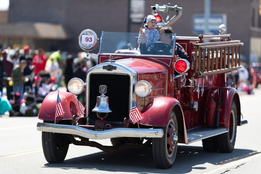 Benton Harbor, Michigan, USA - May 4, 2019: Blossomtime Festival Grand Floral Parade, Man driving an antique St Joseph firetruck during the parade