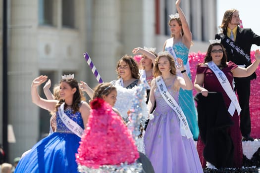 Benton Harbor, Michigan, USA - May 4, 2019: Blossomtime Festival Grand Floral Parade, Float carrying Miss River Valley and her court during the parade