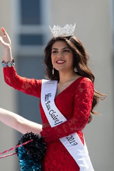 Benton Harbor, Michigan, USA - May 4, 2019: Blossomtime Festival Grand Floral Parade, Float carrying  Miss Eau Claire and her court during the parade