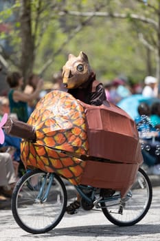 Cleveland, Ohio, USA - June 8, 2019: Parade the Circle, Person wearing a squirrel outfit riding a bicycle in shape of a nut