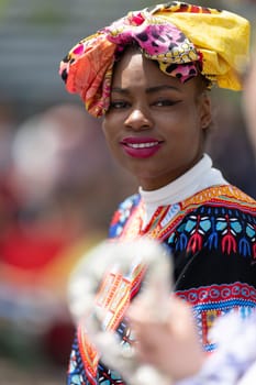 Cleveland, Ohio, USA - June 8, 2019: Parade the Circle, African American woman wearing a colorful outfit, looks and smiles at the camera
