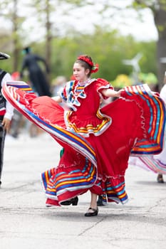 Cleveland, Ohio, USA - June 8, 2019: Parade the Circle, young woman wearing traditional mexican clothing dancing