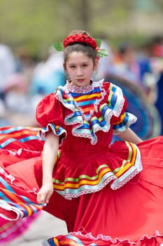 Cleveland, Ohio, USA - June 8, 2019: Parade the Circle, young woman wearing traditional mexican clothing dancing