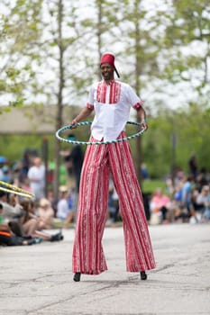 Cleveland, Ohio, USA - June 8, 2019: Parade the Circle, African American man on stilts playing with a hula hoop during the parade