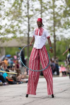 Cleveland, Ohio, USA - June 8, 2019: Parade the Circle, African American man on stilts playing with a hula hoop during the parade