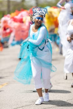 Cleveland, Ohio, USA - June 8, 2019: Parade the Circle, African American woman wearing a colorful outfit, dancing during the parade