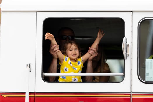 Louisville, Kentucky, USA - May 2, 2019: The Pegasus Parade, firefighter playing with his daugther inside a fire truck during the parade