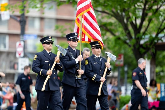 Louisville, Kentucky, USA - May 2, 2019: The Pegasus Parade, Louisville Fire Fighters escorting the American flag during the parade
