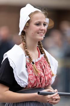 Holland, Michigan, USA - May 11, 2019: Tulip Time Parade, Young woman wearing traditional dutch clothing marching down the street during the parade