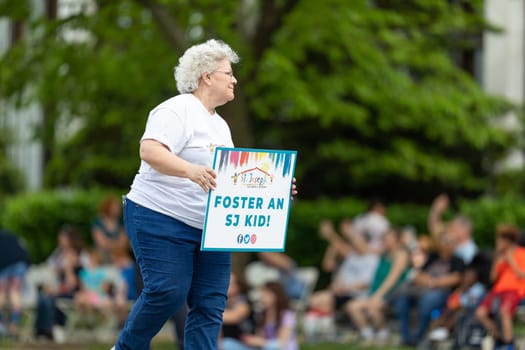 Louisville, Kentucky, USA - May 2, 2019: The Pegasus Parade, women carrying signs promoting child adoption during the parade