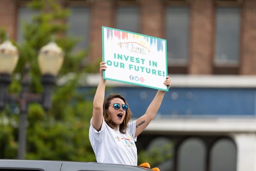 Louisville, Kentucky, USA - May 2, 2019: The Pegasus Parade, women carrying signs promoting child adoption during the parade