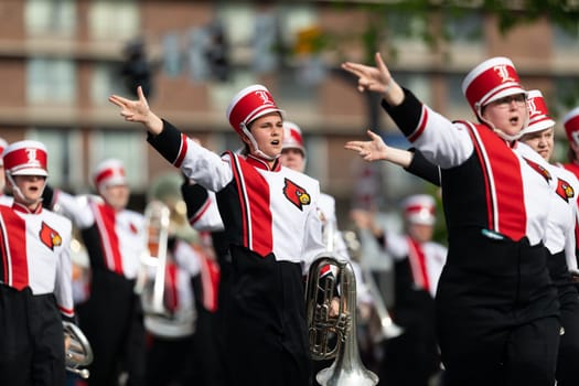 Louisville, Kentucky, USA - May 2, 2019: The Pegasus Parade, Members of the University of Louisville cheerleaders and marching band performing at the parade