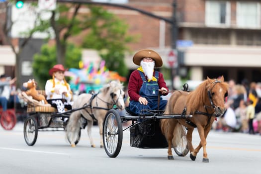 Louisville, Kentucky, USA - May 2, 2019: The Pegasus Parade, Women dress up as toy story characters, riding carriages pulled by ponys during the parade