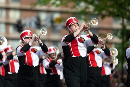 Louisville, Kentucky, USA - May 2, 2019: The Pegasus Parade, Members of the University of Louisville cheerleaders and marching band performing at the parade