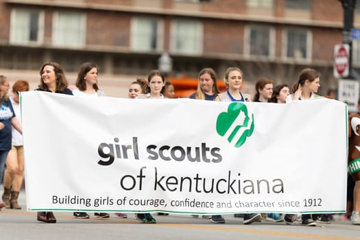 Louisville, Kentucky, USA - May 2, 2019: The Pegasus Parade, Young women carrying a banner promoting the Girl Scouts of Kentuckiana during the parade