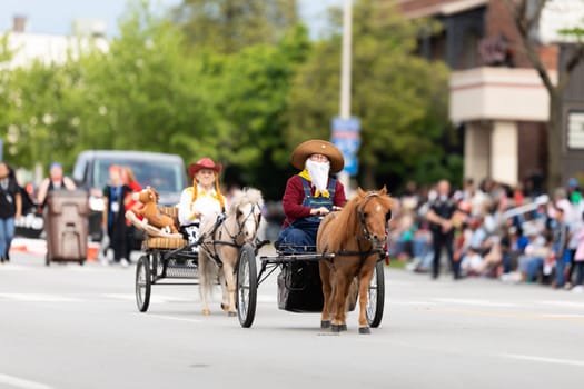 Louisville, Kentucky, USA - May 2, 2019: The Pegasus Parade, Women dress up as toy story characters, riding carriages pulled by ponys during the parade