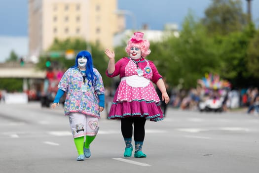 Louisville, Kentucky, USA - May 2, 2019: The Pegasus Parade, Two women dress up as clowns waving at the spectators during the parade