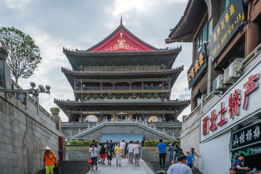 Xian, China -  July 2019 : People walking towards the landmark Drum Tower in the city Xian, Shaaxi Province