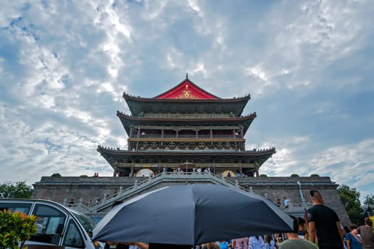 Xian, China -  July 2019 : Person with an umbrella in front of the landmark Drum Tower in the city Xian, Shaaxi Province