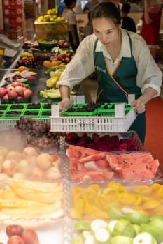 Xian, China -  July 2019 : Female selling freshly cut fruits in a stall in Muslim Quarter in Xian town, Shaanxi Province