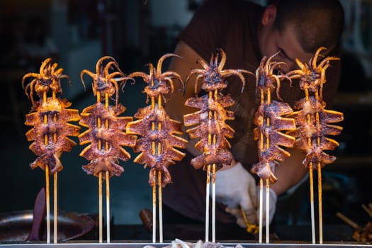 Xian, China -  July 2019 : Meat, snacks, calamari and fried baby octopus vendor selling food on the street in the Muslim Quarter